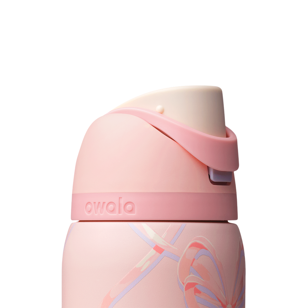 Owala FreeSip 32oz in Sugar Plum Fairy, close-up of pink flip cap with cream interior and pink carry loop folded over against the patterned body